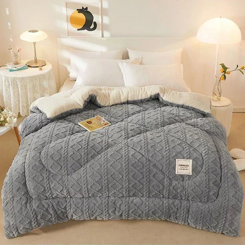 A beautifully made bed covered with the Luxury Cashmere Weighted Blanket, displaying its plush coral fleece texture and elegant design. The blanket drapes smoothly over the bed, enhancing the cozy atmosphere of the room with stylish decor elements in the background.